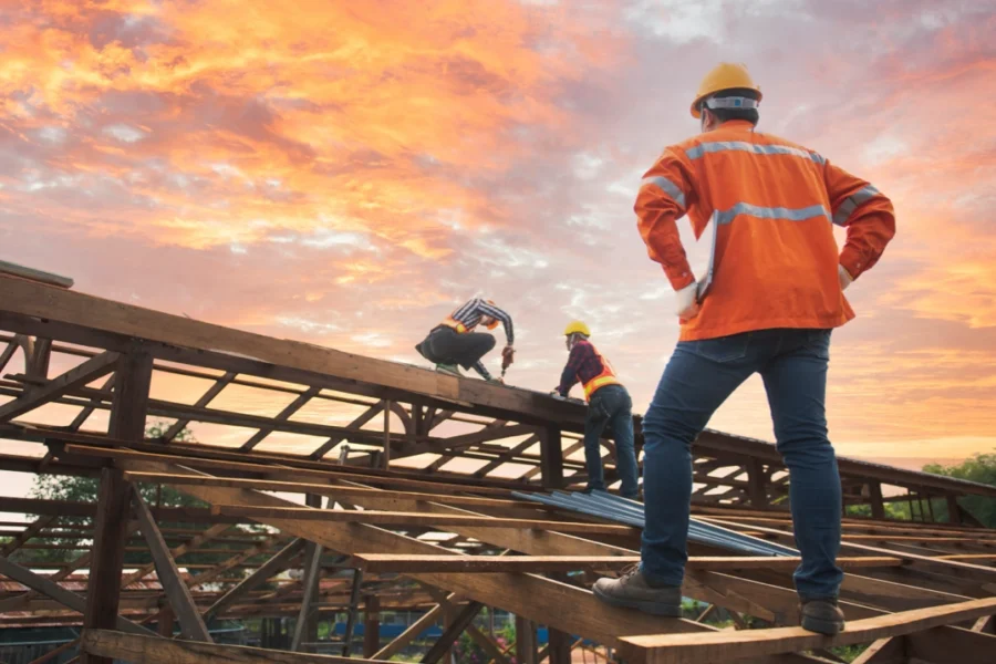 contractor and worker on the roof of a framed out house